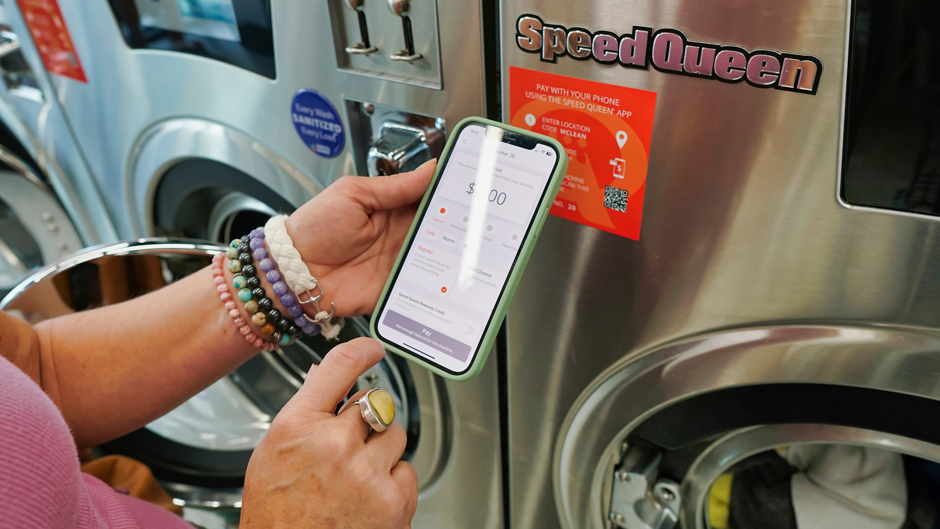 College student using Speed Queen self-service laundry machines at mClean Laundry Rockwood location.